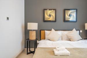 Primestay - 1BR in Prime Views Al Meydan في دبي: غرفة نوم بسرير مع صورتين على الحائط