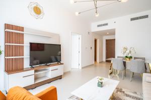 a living room with a television and a table at Primestay - Prime Views Meydan 1BR in Dubai