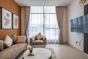a living room with a couch and a chair at Primestay - Prime Views 1BR in Al Meydan in Dubai