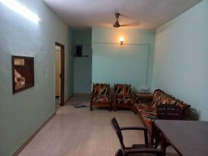 - un salon avec un canapé, une table et des chaises dans l'établissement 2 Bhk Holiday home near Panjim city & Beaches, à Panaji