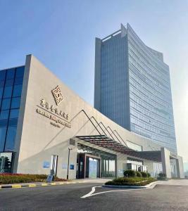 a large building with a sign in front of it at Jingling Grand Hotel Gaochun in Gaochun