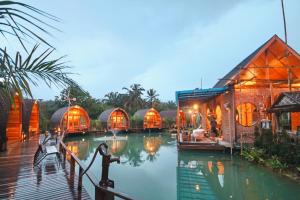 a group of domes on a body of water at Plaiphu Pool Villas in Phangnga