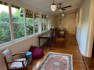 een woonkamer met een tafel, stoelen en ramen bij Wonga - A secluded oasis in the heart of Parkes in Parkes