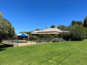 un parque con una casa y un césped con una valla en Wonga - A secluded oasis in the heart of Parkes, en Parkes