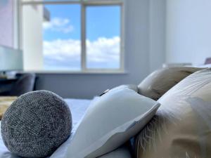 um sofá com almofadas e uma janela em Amzing Ocean View Spacious Three Bedrooms Apartment Port Melbourne em Melbourne