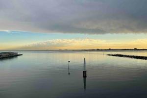 a large body of water with a pole in the water at Amzing Ocean View Spacious Three Bedrooms Apartment Port Melbourne in Melbourne