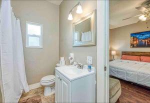 a bathroom with a sink and a toilet and a bed at 2 King Beds! Fantastic Stylish Bungalow home! in Fresno +22 photos