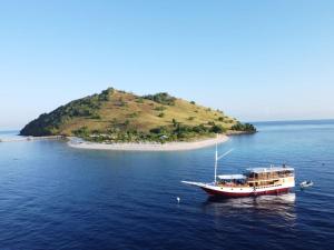 a boat in the water next to an island at Family Labuan Bajo in Labuan Bajo