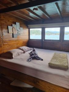 a large bed with a teddy bear sitting on it at Family Labuan Bajo in Labuan Bajo