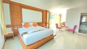 a bedroom with a bed and a table and chairs at Sukcheewa Residence Phuket in Patong Beach