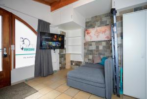 ein Wohnzimmer mit einem Sofa und einem Flachbild-TV in der Unterkunft Solution-Grischun, Parkplatz - Küche- Wäschetrokner- Kaffee, Tee in Flims