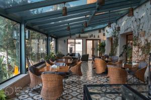 a restaurant with wooden tables and chairs and windows at Guest House Hotel Amman by FHM in Amman