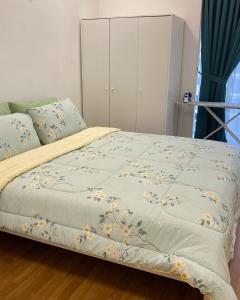 ein Bett mit einer blauen Decke mit Blumen drauf in der Unterkunft AZ Stayz Homestay in Kajang