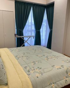 ein Bett mit einer blauen Decke mit Blumen drauf in der Unterkunft AZ Stayz Homestay in Kajang