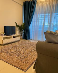 ein Wohnzimmer mit einem Sofa und einem TV in der Unterkunft AZ Stayz Homestay in Kajang