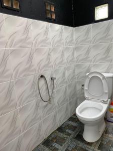 a bathroom with a toilet with a hanger on the wall at HOMESTAY Kampong KOTA AUR Resort with swimming pool, Kepala Batas, SEBERANG PERAI, PENANG -MOTAC registered Awarded ASEAN homestay standard Malaysia AWARD 2023-2028 Only 3 minutes from viral KG AGONG in Kepala Batas