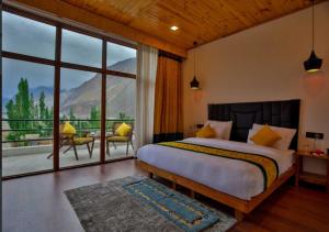 CharāsaThe Dunes Boutique Hotel的一间带大床和大窗户的卧室