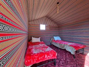 Wadi rum galaxy camp في وادي رم: غرفة نوم بسريرين في غرفة ذات سقف