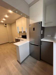 an empty room with a kitchen with a refrigerator at Zhalgin's apartments in (( Turksib ))