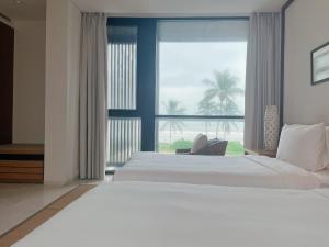 峴港的住宿－Luxury Beach Resort Apartments & Villas，一间卧室设有一张大床和一个大窗户