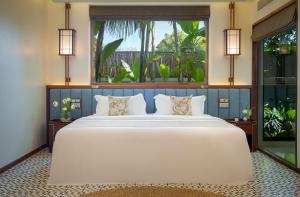 WAKA VILLA Private Resort & Spa - Adults Only في سيام ريب: غرفة نوم بسرير ابيض كبير ونافذة كبيرة