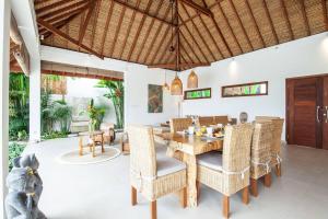 a dining room with a wooden table and chairs at Villa Matigo Canggu in Canggu