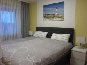 a bedroom with a bed with a lighthouse on the wall at Hanseat II - Whg 183 "Meeresperle" in Grömitz