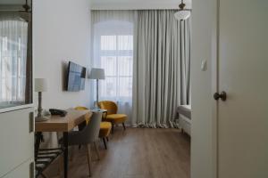 a hotel room with a table and chairs and a bedroom at Art Hotel in Wrocław