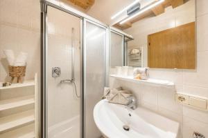 a white bathroom with a shower and a sink at Eichernhof Apartment Apfelblüte in Verano