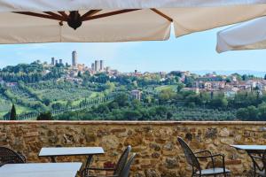 a view of the city from a restaurant with tables and chairs at Podere Sant'Elena in San Gimignano