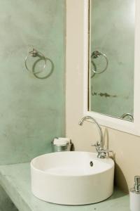 St George's Guest House في تزانين: حمام مع حوض أبيض ومرآة