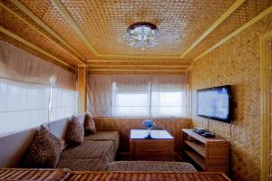 ein Wohnzimmer mit einem Sofa und einem TV in der Unterkunft Foxy's Beach Resort in San Vicente