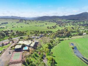 an aerial view of a farm with mountains in the background at Off Mountain Accommodation in Merrijig