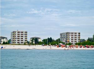 een strand met twee hoge gebouwen en mensen op het strand bij Hanseat II - Whg 183 "Meeresperle" in Grömitz