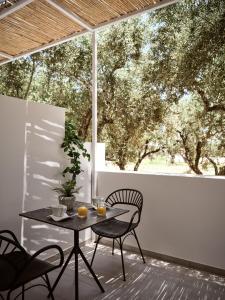 een tafel en stoelen op een patio met een groot raam bij Sanpiero Island in Zakynthos