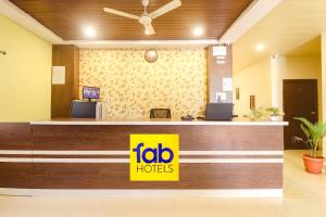 a hotel lobby with a yellow sign on the counter at FabExpress Airport Stay Inn in Hyderabad