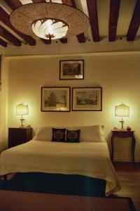 um quarto com uma cama grande e 2 candeeiros em Al pozzo dei Scoacamini, 100 m from San Marco, ground floor em Veneza