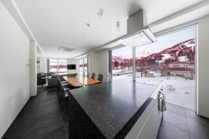 a kitchen with a dining table and a large window at Bluebird Apartments by The Hakuba Collection in Hakuba