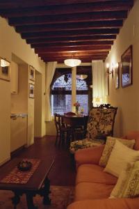 uma sala de estar com um sofá e uma mesa em Al pozzo dei Scoacamini, 100 m from San Marco, ground floor em Veneza