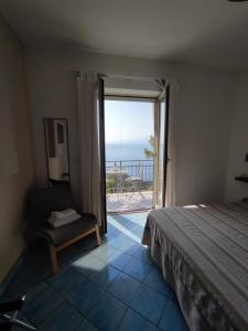 a bedroom with a bed and a view of the ocean at Judia Camere sul mare in Maratea
