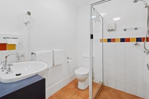 a bathroom with a sink and a toilet and a shower at Browns Plains Motor Inn in Browns Plains