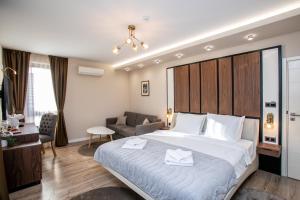 a hotel room with a large bed and a couch at B&D Apartments Delux, NEW in Lovech