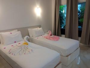 dwa łóżka z różowymi flamingami w pokoju w obiekcie Thoddoo Garden inn w mieście Thoddoo