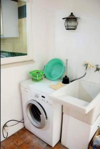 ein Badezimmer mit einer Waschmaschine und einem Waschbecken in der Unterkunft Apartamento Cómodo y céntrico en Olot in Olot