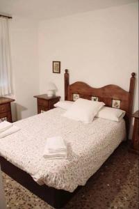 Schlafzimmer mit einem großen Bett mit einem Kopfteil aus Holz in der Unterkunft Apartamento Cómodo y céntrico en Olot in Olot