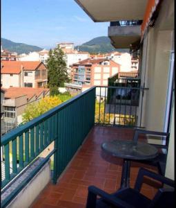 einen Balkon mit einem Tisch und Stadtblick in der Unterkunft Apartamento Cómodo y céntrico en Olot in Olot