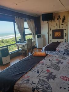 a bedroom with two beds and a view of the ocean at Deep Blue Guest House in Amanzimtoti