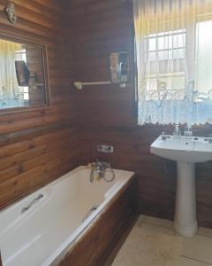 a bathroom with a bath tub and a sink at Deep Blue Guest House in Amanzimtoti