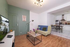 ein Wohnzimmer mit einem Sofa und einem Tisch in der Unterkunft Appart calme avec parking proche place Ney in Angers