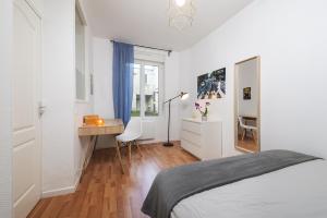 a white bedroom with a desk and a bed at Appart calme avec parking proche place Ney in Angers